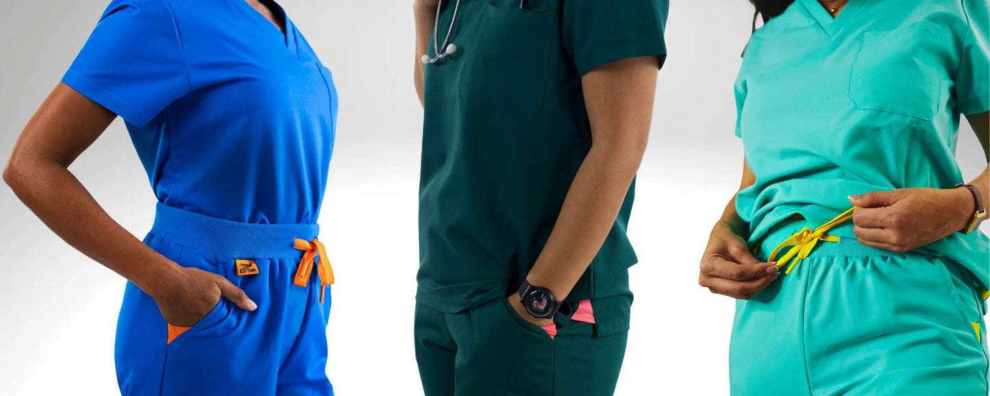 Three women healthcare professionals wearing Estiva medical scrubs in deep teal, royal blue and light blue on a white background.
