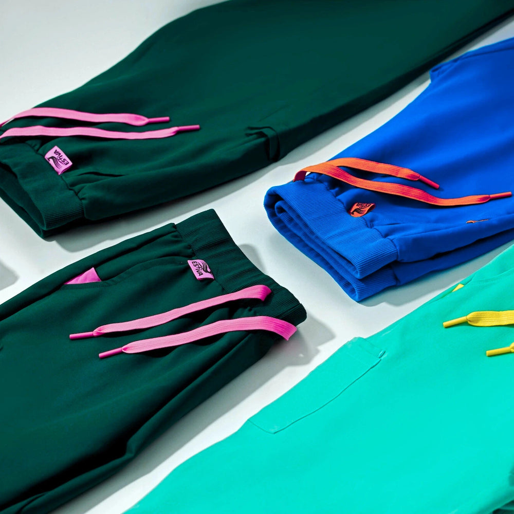 Colorful Estiva scrub pants with signature drawstring details in teal, royal blue, deep green, and turquoise, designed for comfort and style.