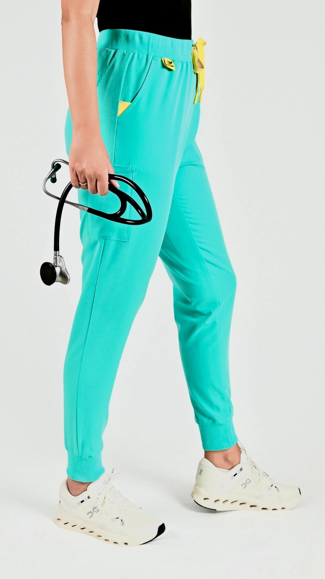 Estiva light turquoise medical scrub pants worn by healthcare professional with stethoscope